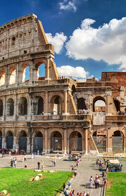 Colosseum in Rome with tourists exploring the ancient amphitheater.