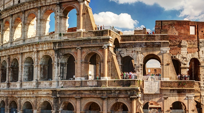 Colosseum in Rome with tourists exploring the ancient amphitheater.