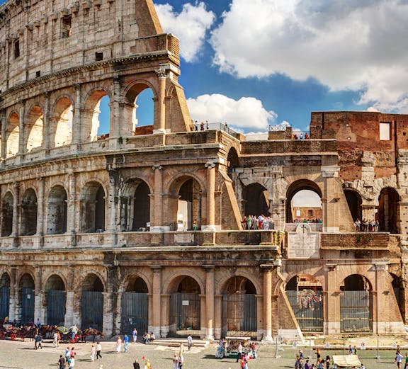 Colosseum in Rome with tourists exploring the ancient amphitheater.