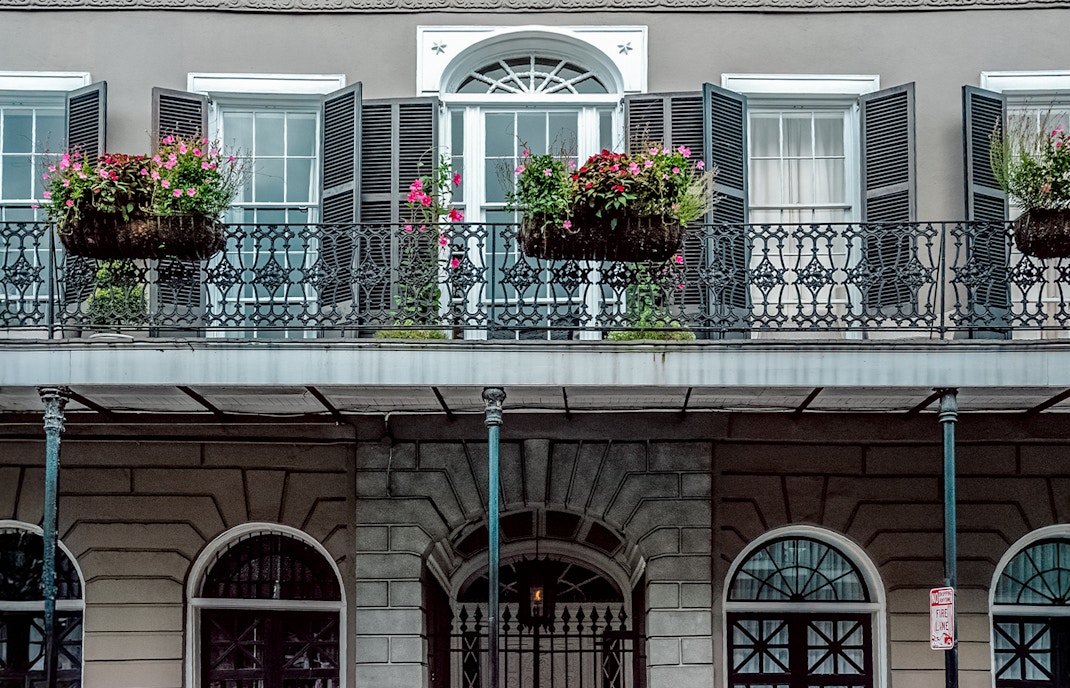 LaLaurie Mansion balcony with ironwork and flowers, New Orleans haunted site.