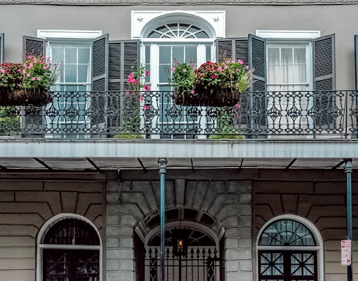 LaLaurie Mansion balcony with ironwork and flowers, New Orleans haunted site.