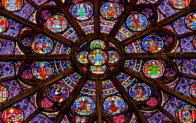 Rose window detail in Notre Dame Cathedral, Paris, featuring vibrant stained glass.