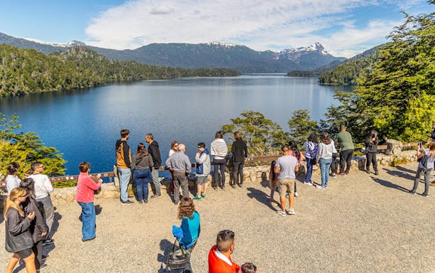Visitors at a viewpoint overlooking Patagonian lakes and mountains.