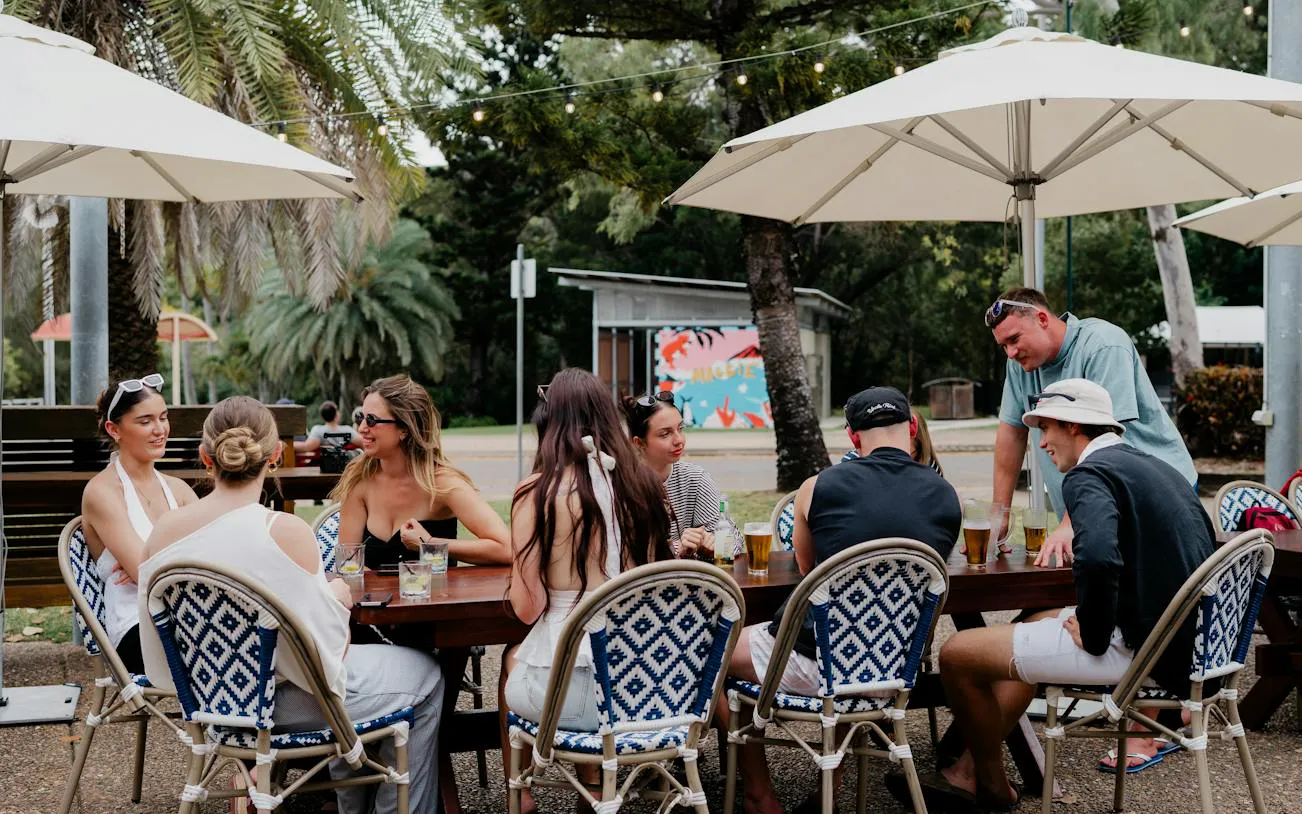 Group enjoying drinks at an outdoor table on Magnetic Island Boat Pub Crawl, Townsville.