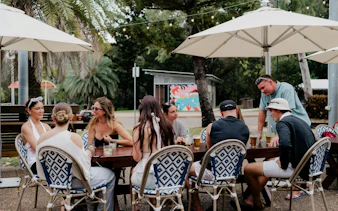 Group enjoying drinks at an outdoor table on Magnetic Island Boat Pub Crawl, Townsville.