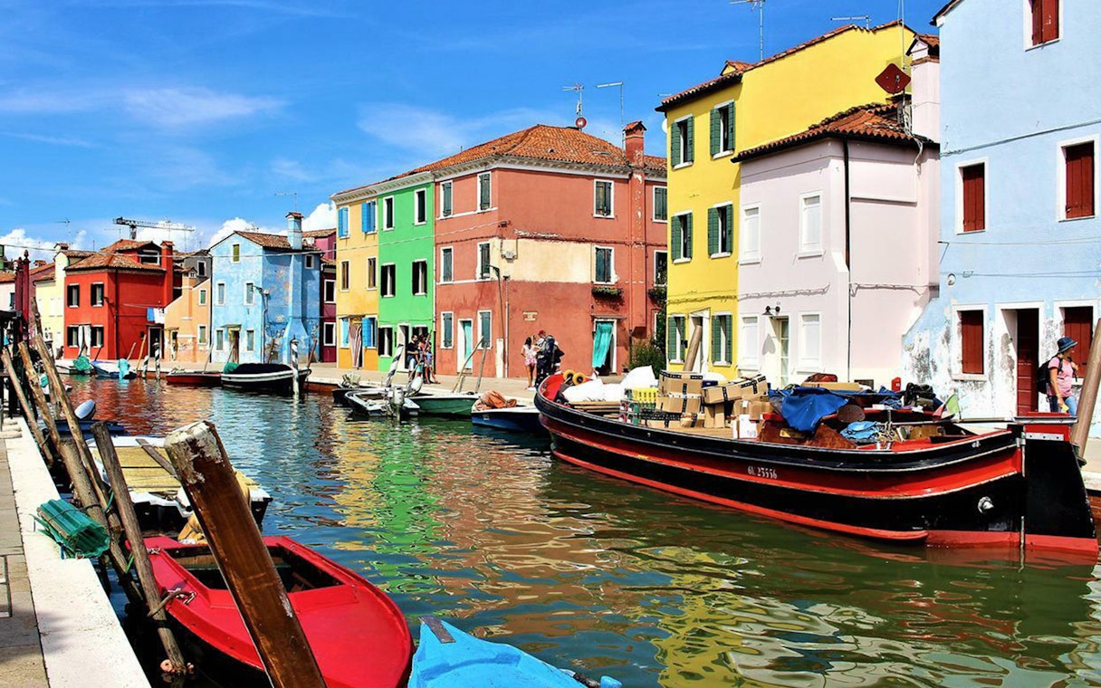 Vividly colored homes along a canal in Burano, Italy.