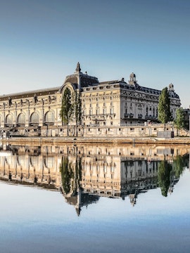 Musée d'Orsay reflecting in the Seine River, Paris, featured in Emily in Paris Tours.