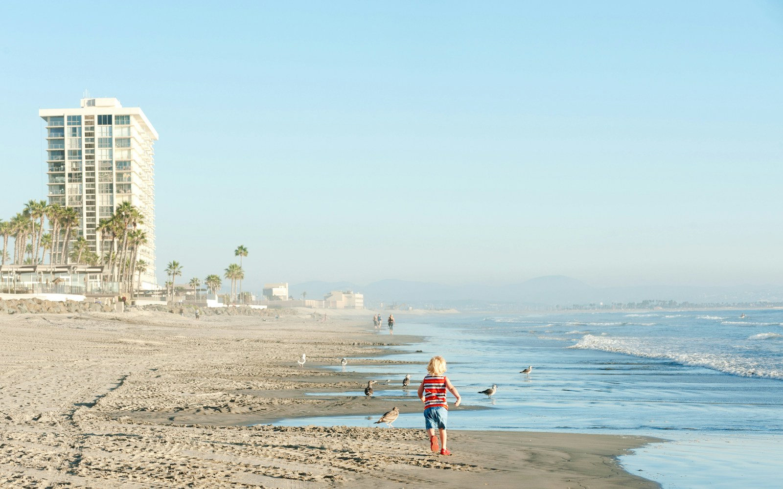 Modern highrise condos along Coronado Beach, San Diego, CA, with ocean view.