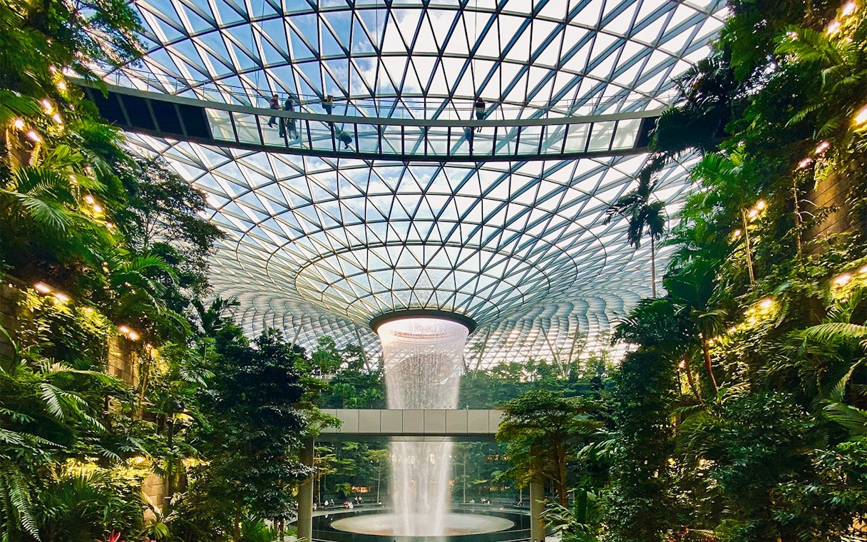 Jewel Changi Canopy Bridge with lush greenery and indoor waterfall.