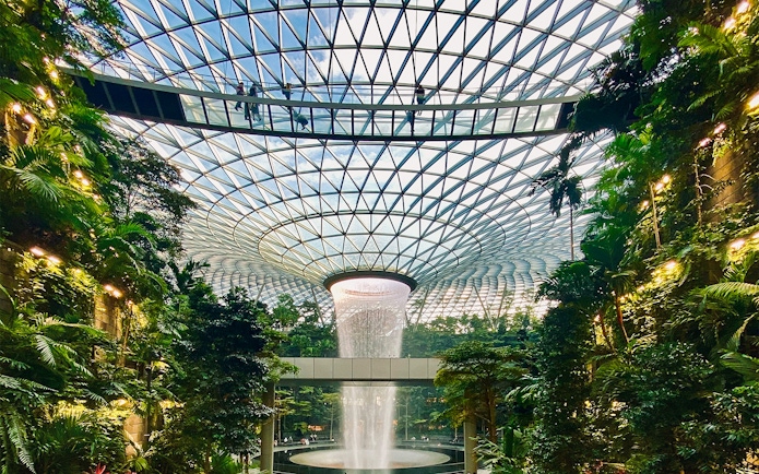 Jewel Changi Canopy Bridge with lush greenery and indoor waterfall.