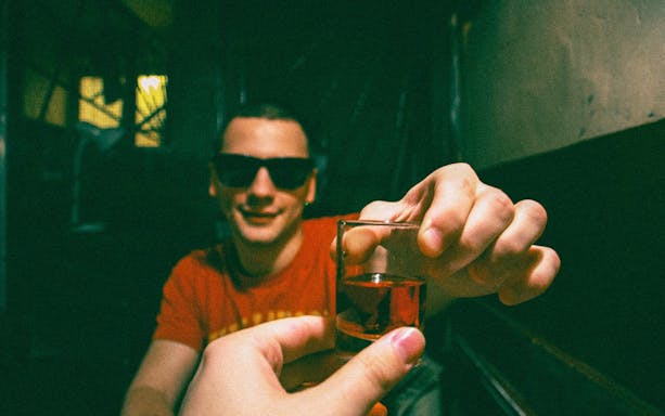 Man holding a shot glass during Vodka and Liqueurs Tour in Krakow.