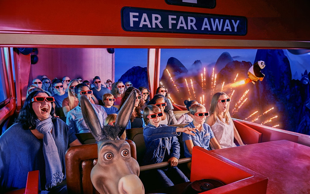 Visitors enjoying a 4D ride at Shrek’s Adventure! London with 3D glasses and animated effects.