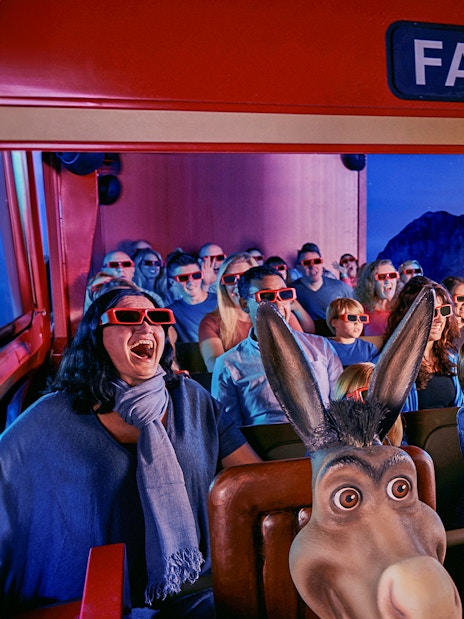 Visitors enjoying a 4D ride at Shrek’s Adventure! London with 3D glasses and animated effects.
