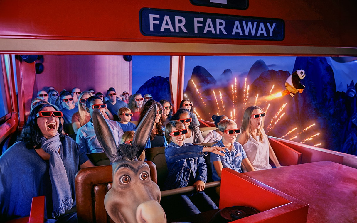 Visitors enjoying a 4D ride at Shrek’s Adventure! London with 3D glasses and animated effects.