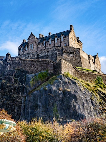 Edinburgh Castle atop Castle Rock under a clear blue sky.