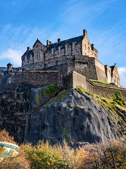 Edinburgh Castle atop Castle Rock under a clear blue sky.