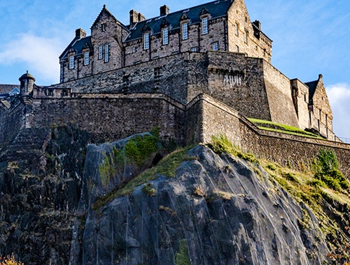 Edinburgh Castle atop Castle Rock under a clear blue sky.