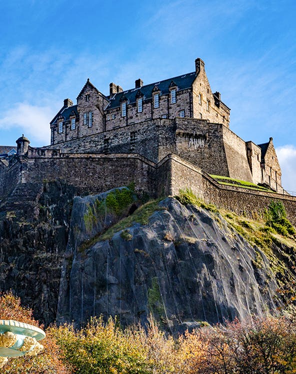 Edinburgh Castle atop Castle Rock under a clear blue sky.