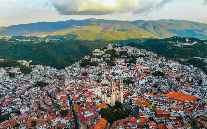 Aerial view of Taxco with Santa Prisca Church and surrounding hills, Mexico City day tour.