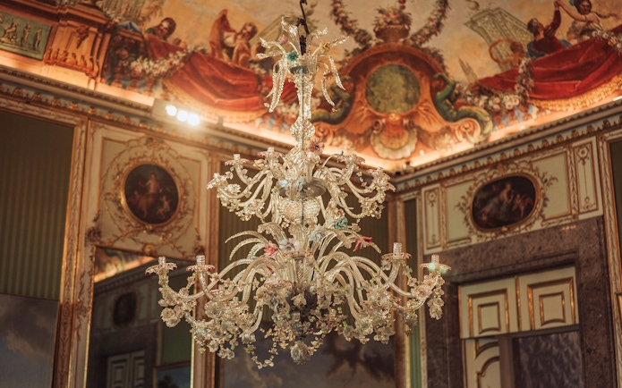 Elegant chandelier and ornate ceiling in the Royal Palace of Caserta.