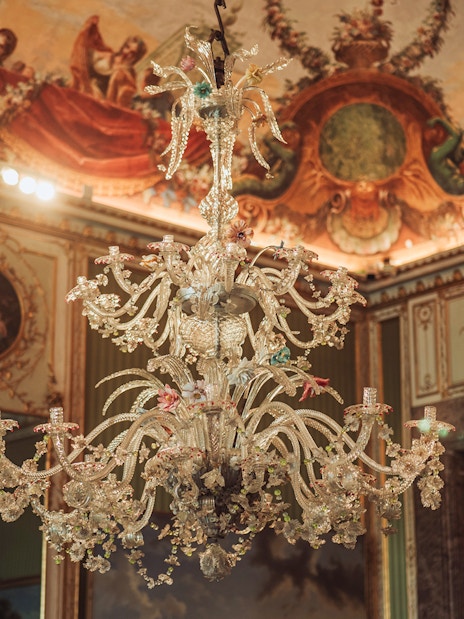 Elegant chandelier and ornate ceiling in the Royal Palace of Caserta.