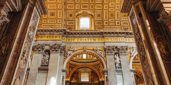 Interior view of St. Peter’s Basilica with ornate columns and detailed ceiling.