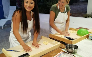 Women making orecchiette pasta in a trullo during a cooking class, Polignano a Mare.