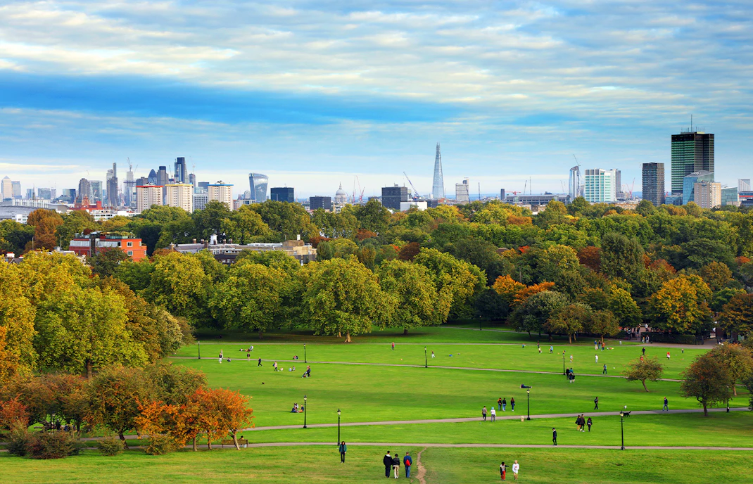 Primrose Hill with London skyline in the background, featuring the Shard and cityscape.