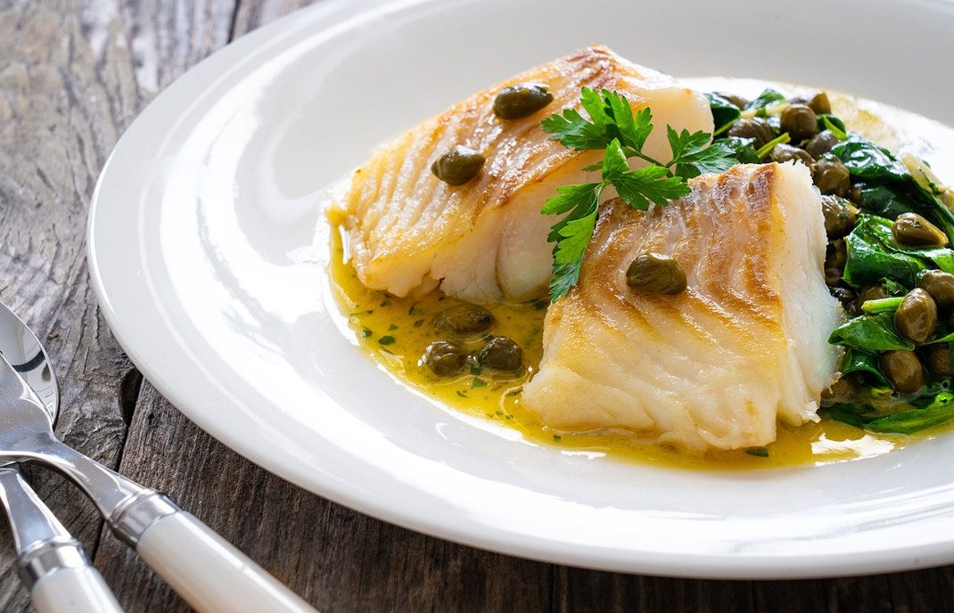 Grilled fish with spinach and capers.
