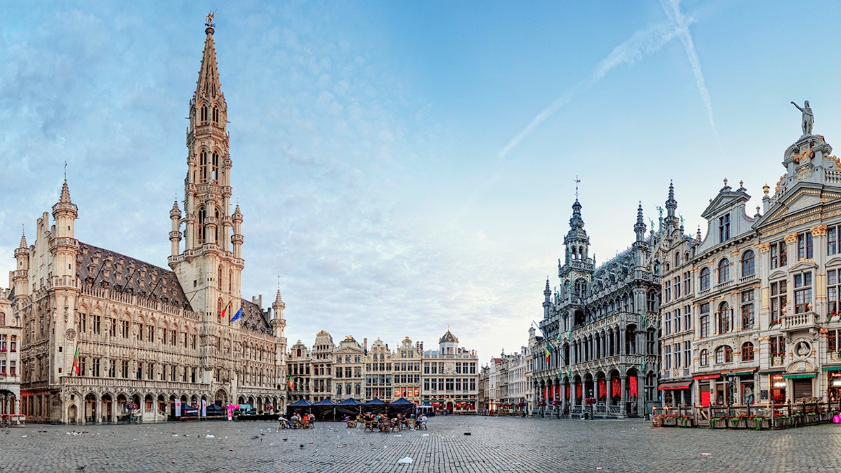 Grand Place Brussels with historic guildhalls and bustling tourists.