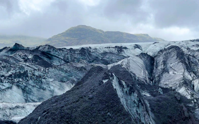 Guests hiking on Sólheimajökull Glacier in Iceland with mountainous backdrop.
