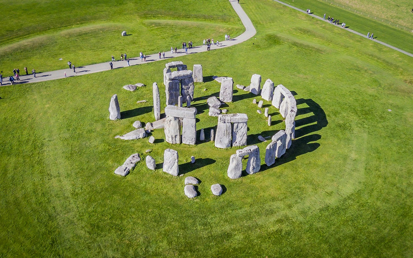 Stonehenge aerial view with tourists on a path, part of a half-day tour from London.
