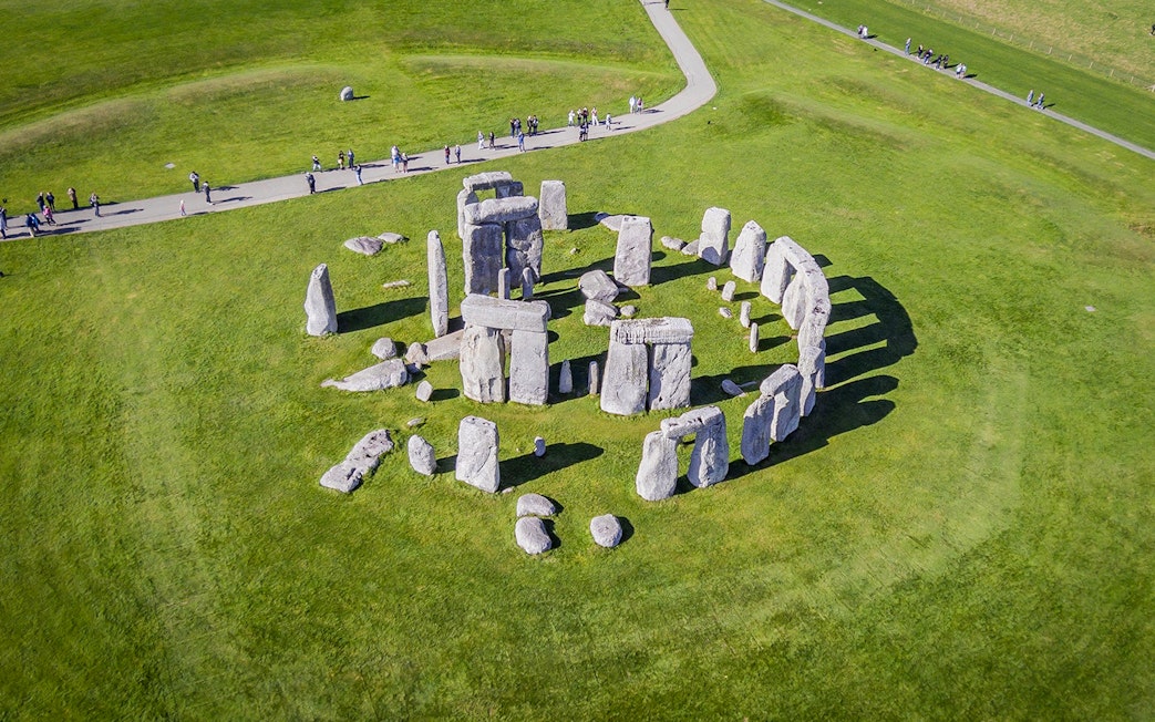 Stonehenge aerial view with tourists on a path, part of a half-day tour from London.