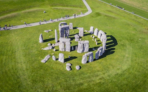 Stonehenge aerial view with tourists on a path, part of a half-day tour from London.
