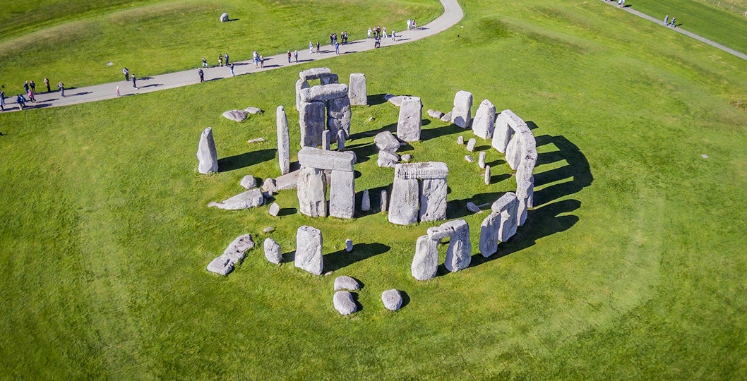 Stonehenge aerial view with tourists on a path, part of a half-day tour from London.