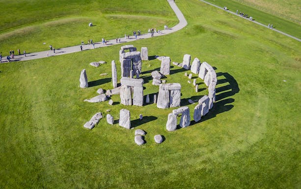 Stonehenge aerial view with tourists on a path, part of a half-day tour from London.