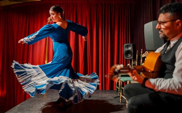 Flamenco dancer performing at Palau Dalmases with guitarist in Barcelona.