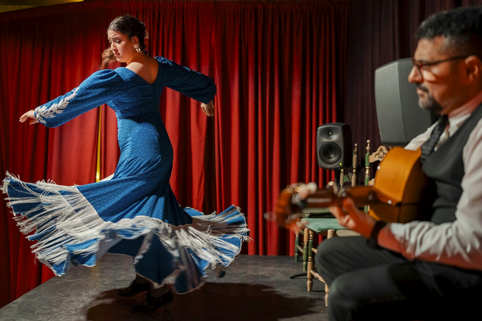 Flamenco dancer performing at Palau Dalmases with guitarist in Barcelona.