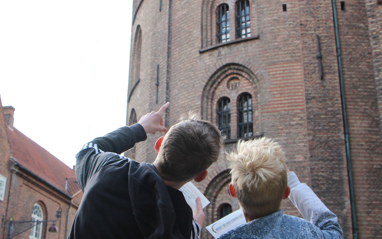 Visitors pointing at Round Tower in Copenhagen during a murder mystery experience.
