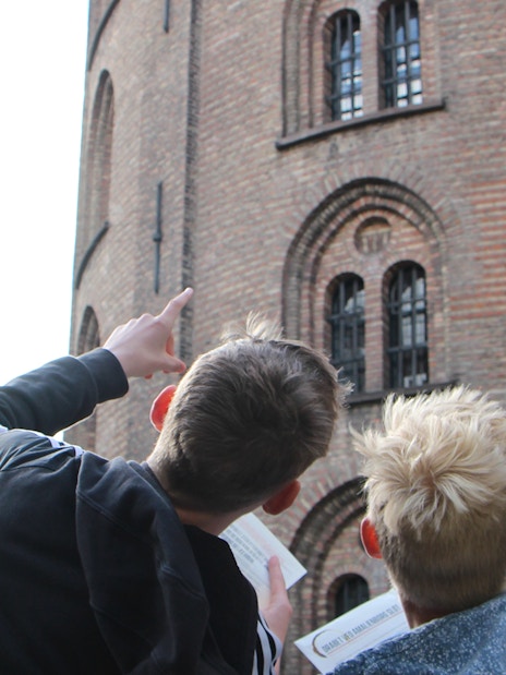 Visitors pointing at Round Tower in Copenhagen during a murder mystery experience.