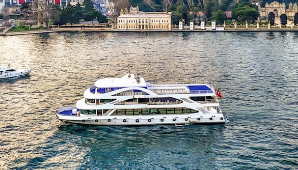 Bosphorus cruise ship sailing near historic Istanbul waterfront.