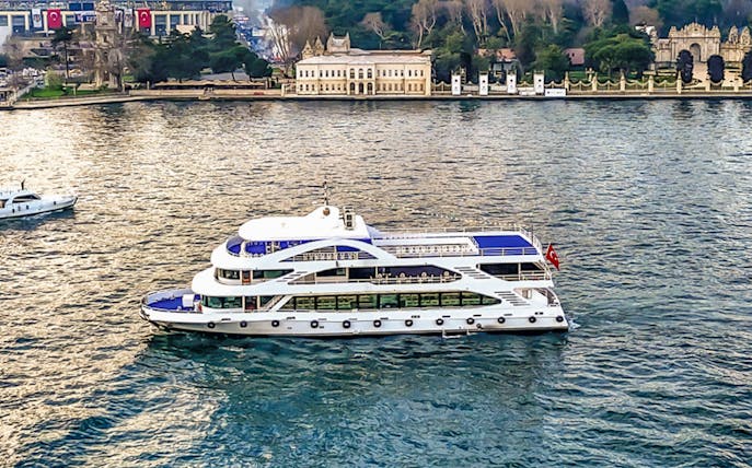 Bosphorus cruise ship sailing near historic Istanbul waterfront.