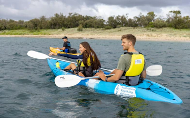 Kayakers paddling near the shore on a guided tour, Gold Coast.