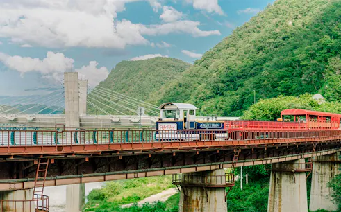 Aerial view of Gangchon Gimnyujeong Rail Bike on a bridge with mountains in the background.