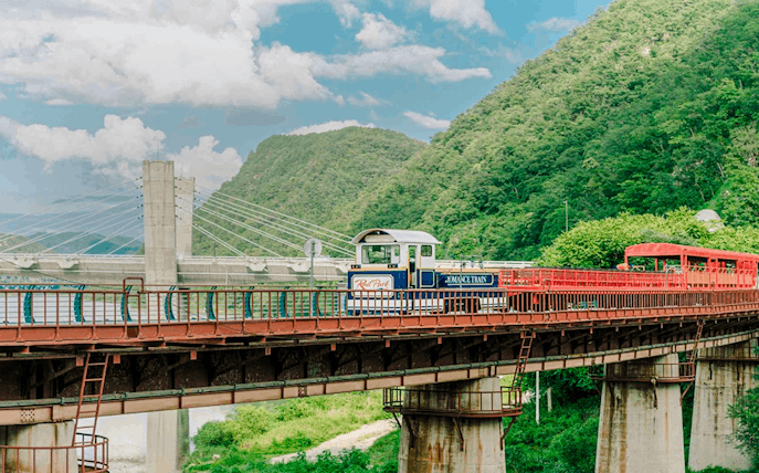 Aerial view of Gangchon Gimnyujeong Rail Bike on a bridge with mountains in the background.