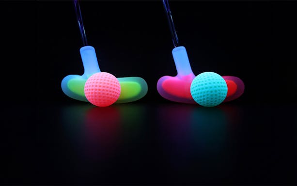 Glowing golf clubs and balls at 3D Blacklight Minigolf in Dubai.