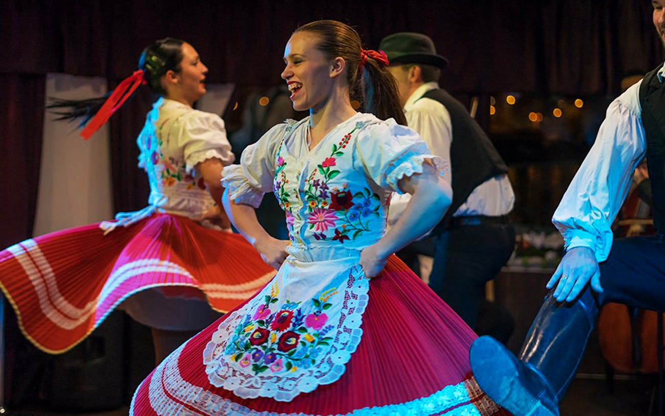 Folk dancers performing in traditional attire during a Budapest dinner cruise.