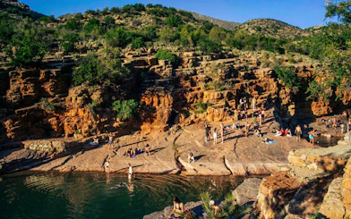 Visitors enjoying the natural rock pools and scenic cliffs of Paradise Valley.