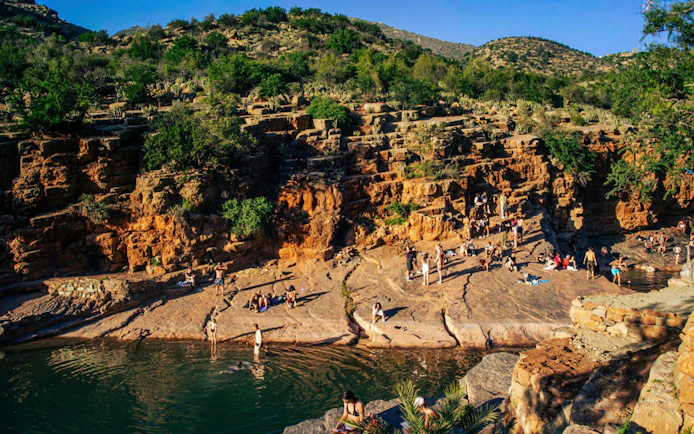 Visitors enjoying the natural rock pools and scenic cliffs of Paradise Valley.
