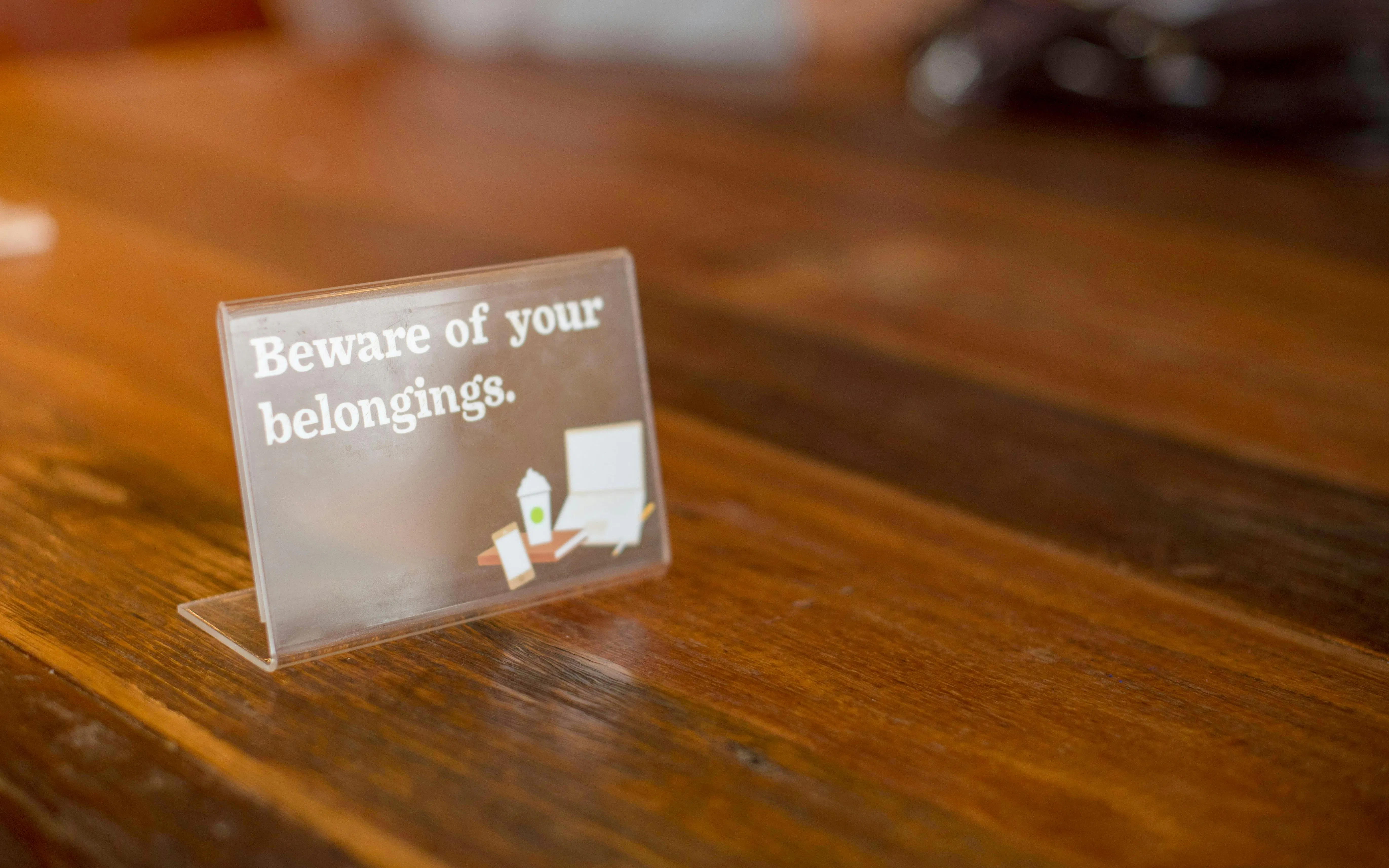 Sign on wooden table warning to beware of belongings at Champ de Mars.